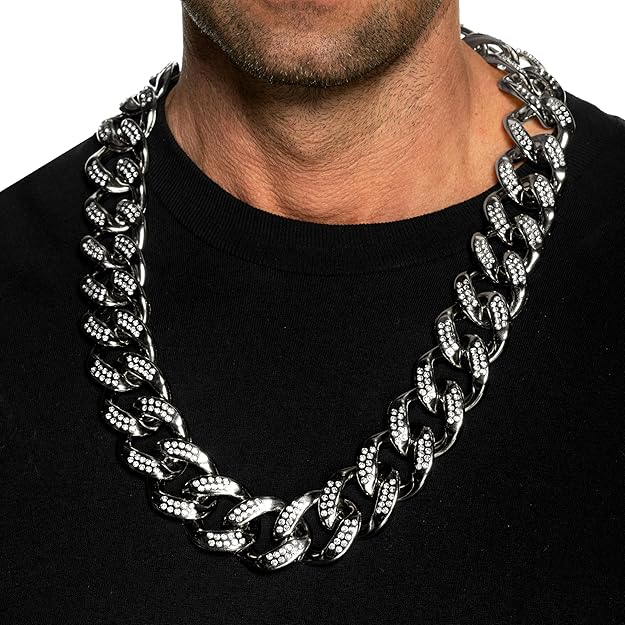 Man wearing a large silver chain necklace on a black background