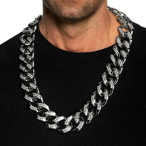 Man wearing a large silver chain necklace on a black background