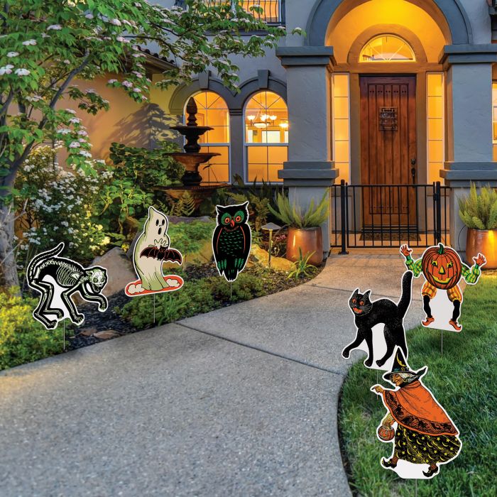 Halloween-themed yard decorations in front of a house with a pathway.