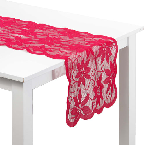 A bright red lace table runner with a floral pattern draped over a white table against a white background.