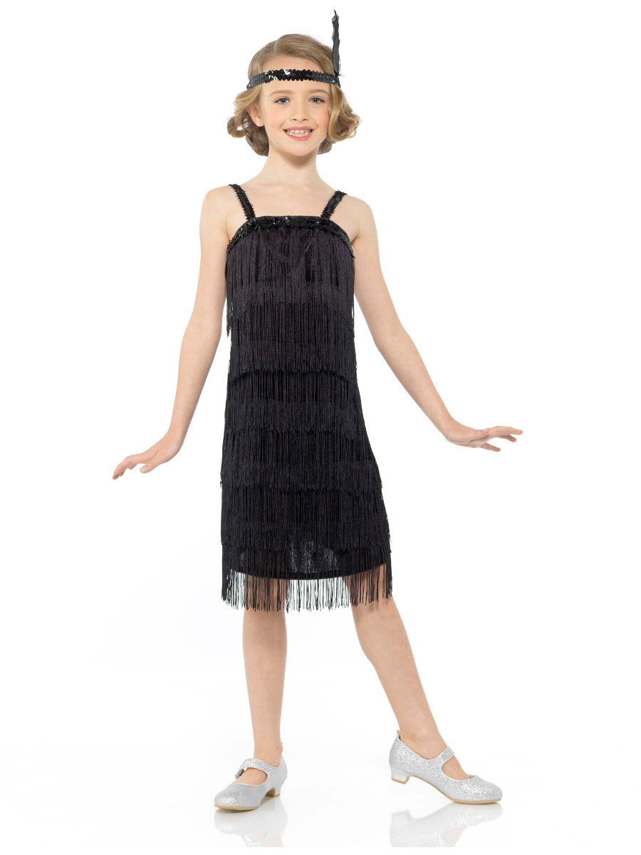 Young girl wearing a black fringe dress with a headband on a white background