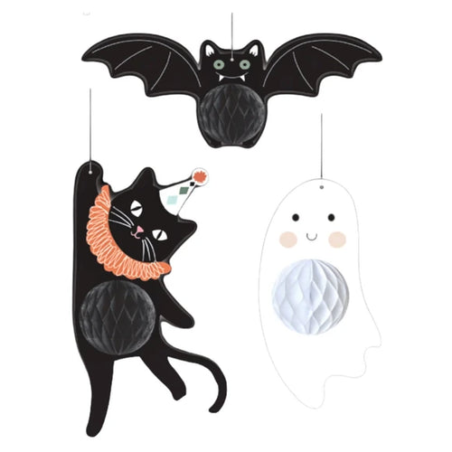 Three Halloween-themed hanging decorations on a plain white background: a black bat at the top, a black cat wearing an orange ruffled collar and party hat on the left, and a white ghost outline with a white honeycomb belly on the right.