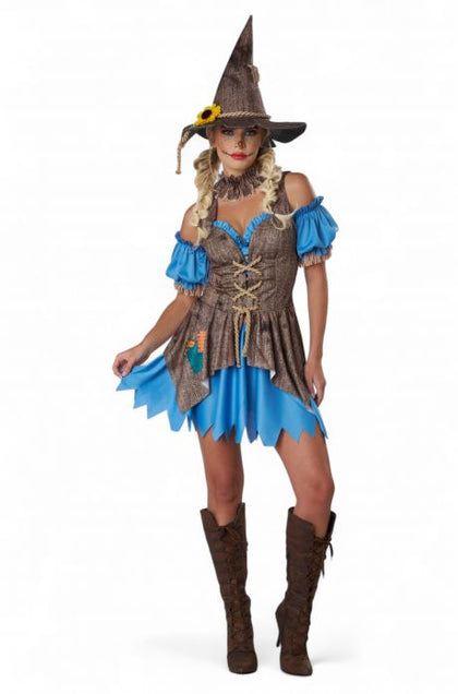Woman wearing a witch costume with a blue dress and brown hat on a white background