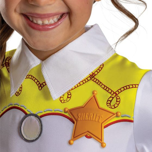 Close-up of a child wearing a sheriff costume top with a white collared shirt, yellow vest, rope print, and a gold sheriff star badge.