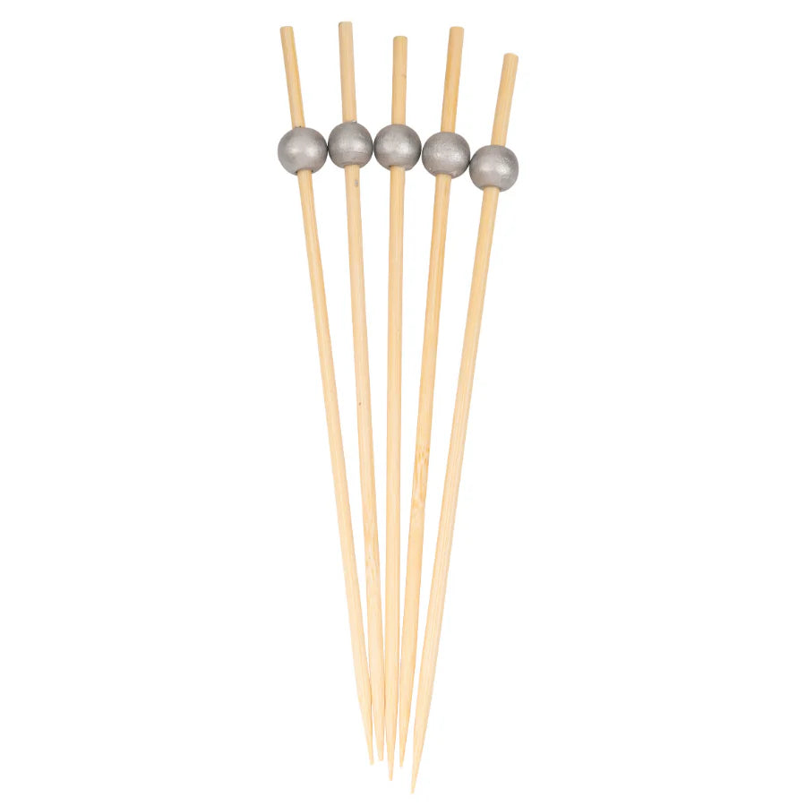 Set of wooden skewers with metal beads on a white background