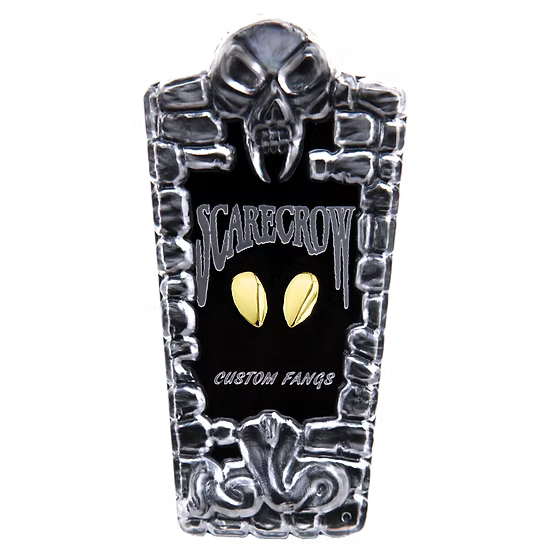 A tombstone-shaped custom fan sign featuring a black center with the words 'SCARECROW' and 'CUSTOM FANGS' in stylized white lettering, flanked by two gold oval eyes, and framed by a silver skull and stone border at the top and bottom.
