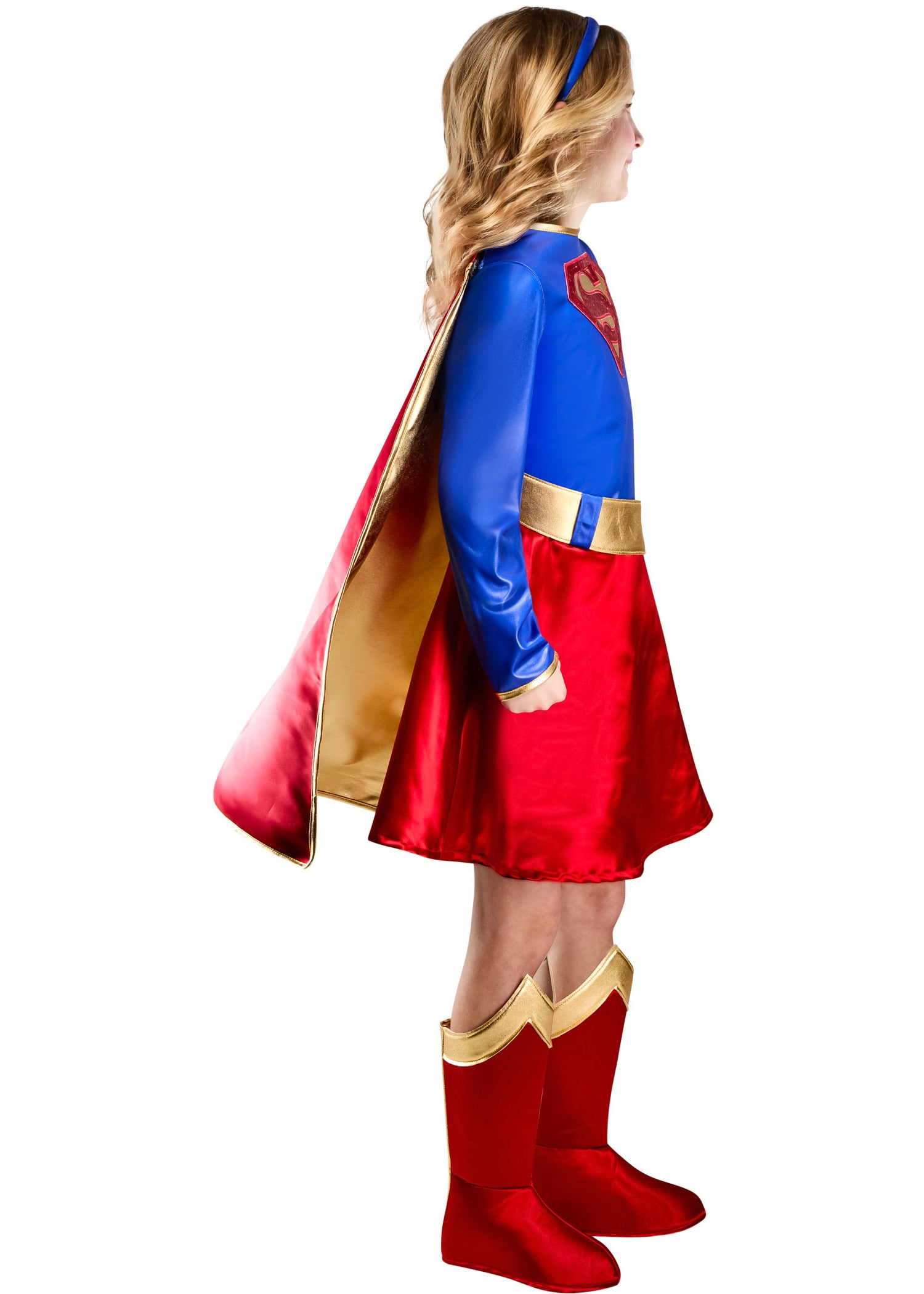 Child wearing a superhero costume with a red cape and boots on a white background