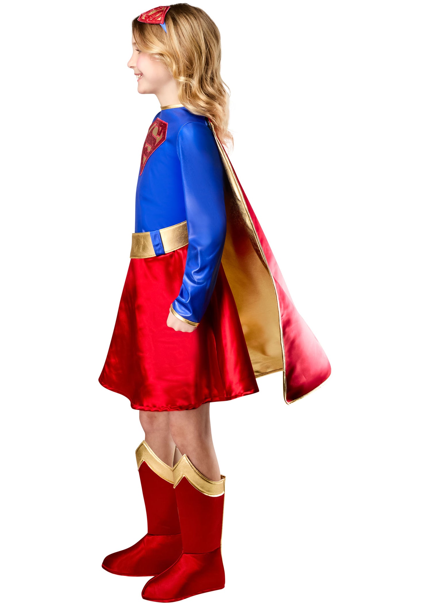 Child wearing a superhero costume with a red cape and boots on a white background