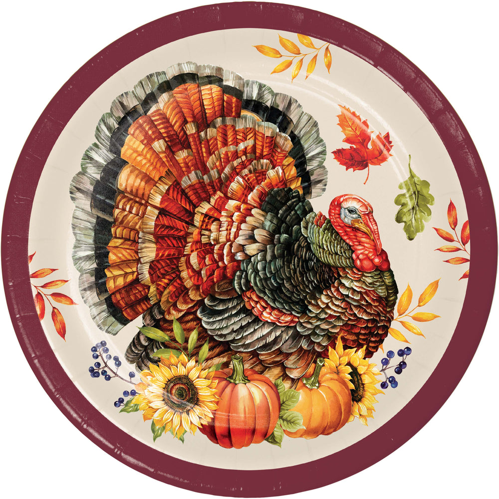 A round paper plate featuring a detailed illustration of a turkey with autumn leaves, pumpkins, and sunflowers, set against a cream background with a dark red rim.