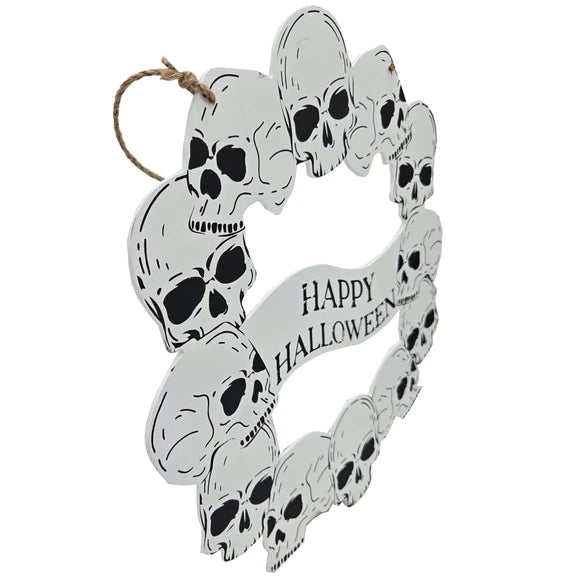 A circular Halloween wall hanging decorated with multiple black-and-white skulls and a banner reading “Happy Halloween,” suspended by a natural twine loop on a plain white background.