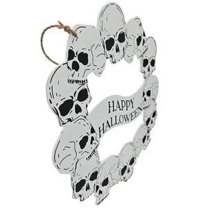 A circular Halloween wall hanging decorated with multiple black-and-white skulls and a banner reading “Happy Halloween,” suspended by a natural twine loop on a plain white background.