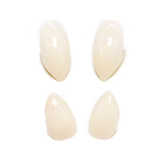 Four glossy, almond-shaped false nails in a warm cream shade, arranged in a 2x2 grid on a solid white background.