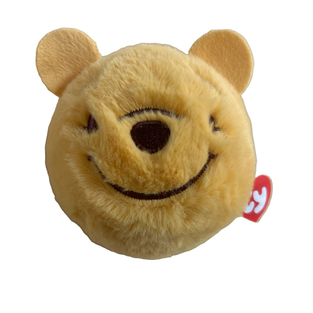 Plush toy bear with a red tag on a beige background