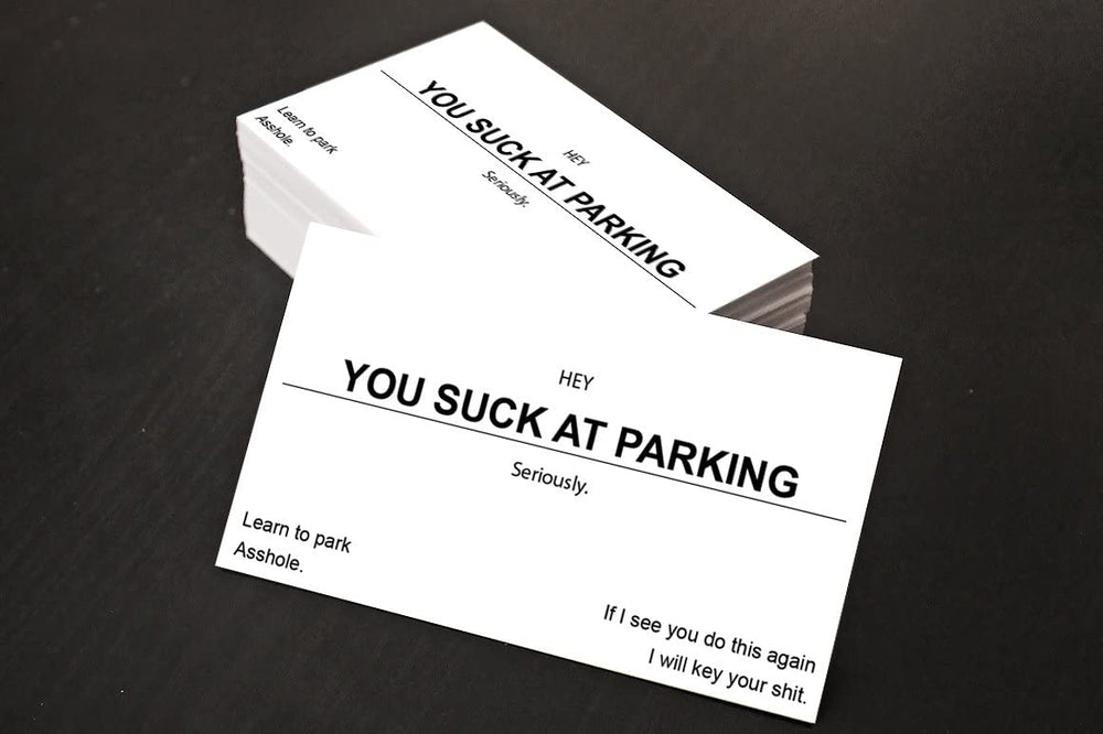 Two business cards with humorous text on a dark surface