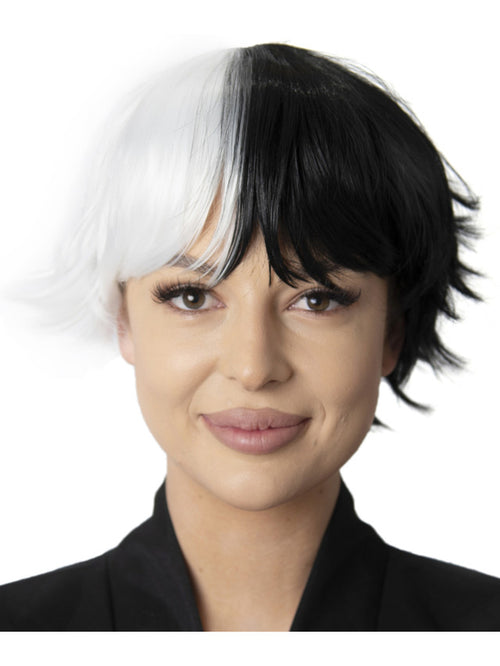 Person with a black and white wig on a plain background